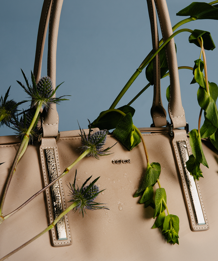 Beige tote bag with plants draped on top.