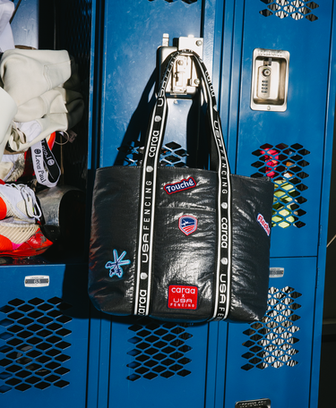 Black bag with visible branding on a blue locker background