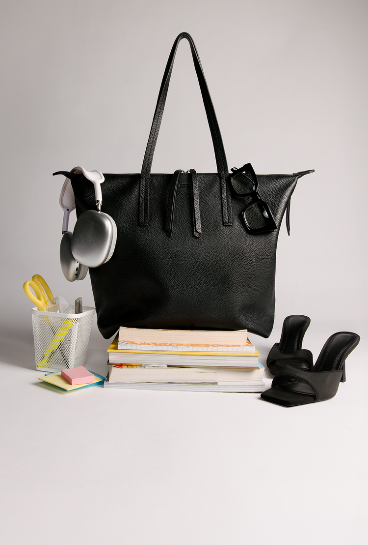 Studio Tote in Black on top of stack of books with office supplies
