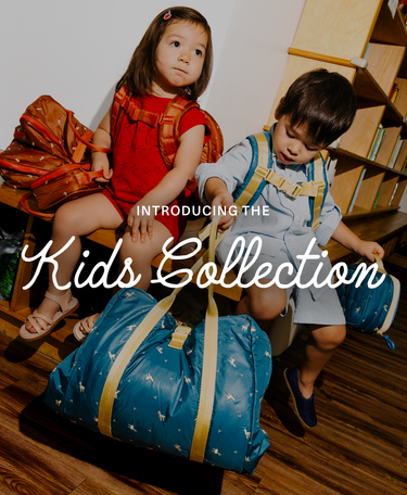 2 Preschool kids on a school bench with bags