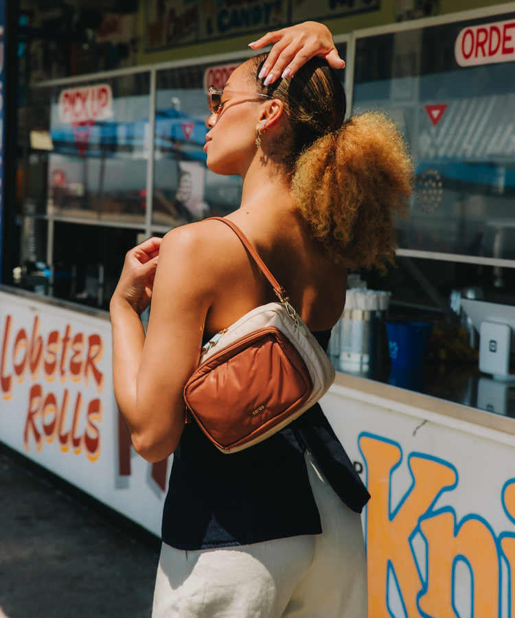 Woman with a brown bag standing in front of a food stand