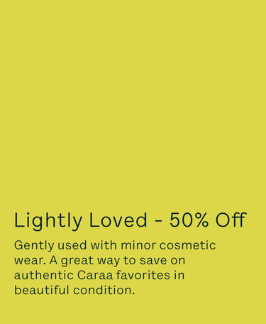 A flat yellow-green promotional graphic with black text reading 'Lightly Loved - 50% Off' and smaller text below about gently used items with minor cosmetic wear.